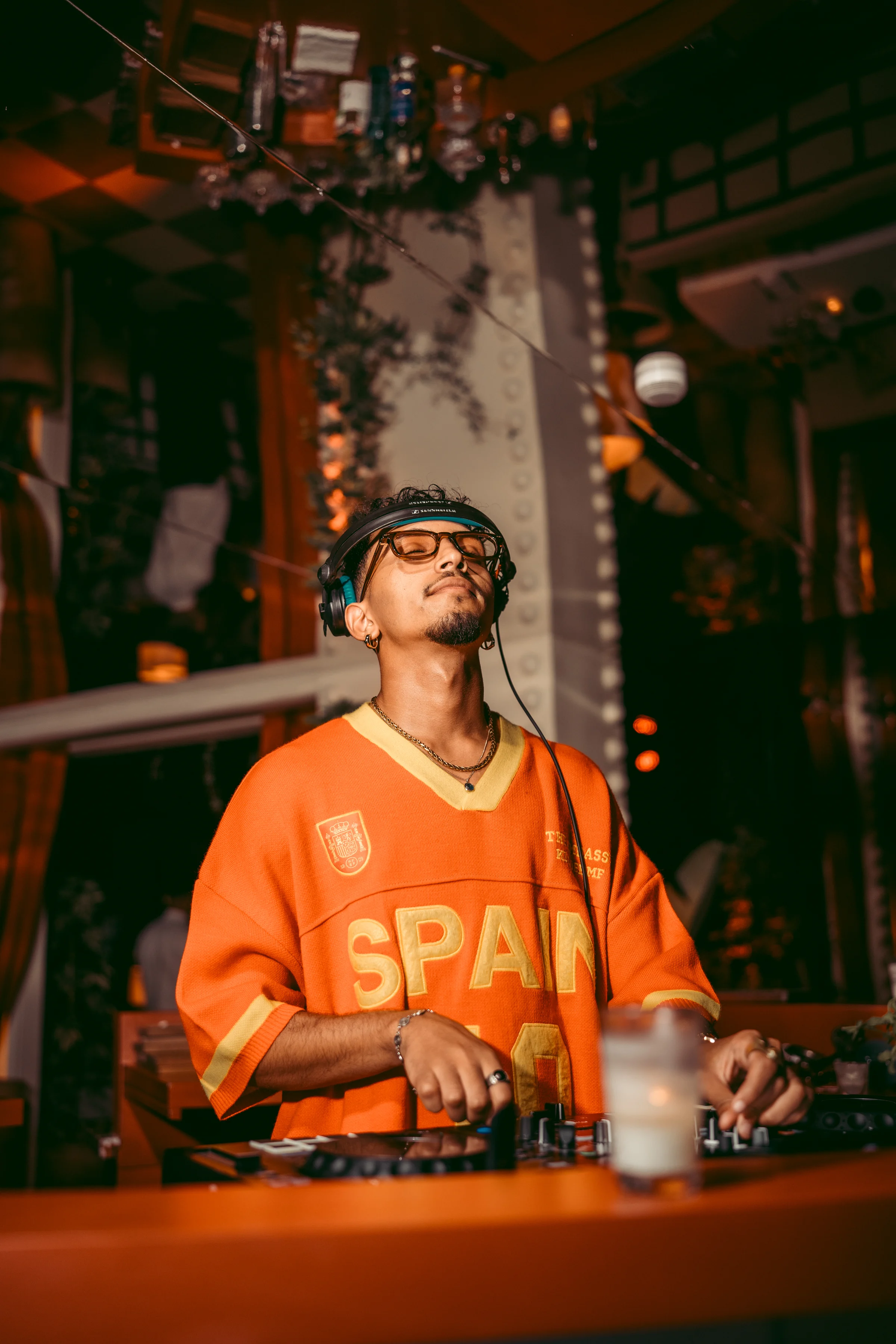 DJ performing in an orange jersey at Coup de Foudre Rooftop
